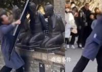 有点上头!男子扛铁板狂砸秦桧雕像 被工作人员连忙阻止