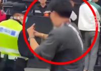 男子对警察竖中指被带走调查 主办方：已被警方带走处理