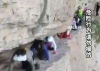 游客狗爬式过悬崖 旅游还是玩命?