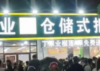 2家水果店斗气式竞争免费送榴莲 大家都撑着伞在雨中排队