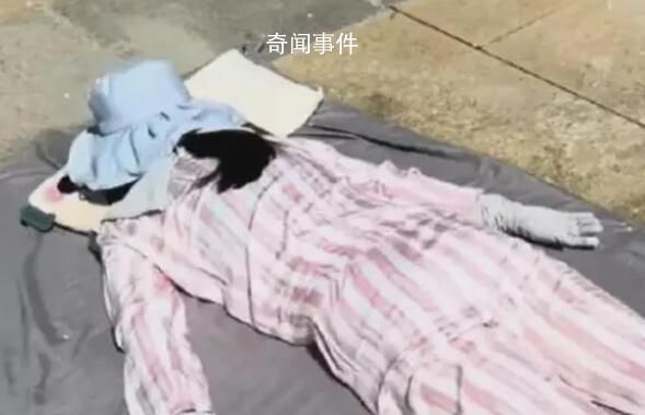 女子高温全副武装趴水泥地上晒背 吸引了大众的眼光