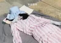 女子高温全副武装趴水泥地上晒背 吸引了大众的眼光