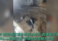 西安城区暴雨街道变河道 汽车在积水中艰难行进