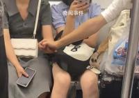 情侣地铁上隔人坐仍手拉手 这究竟是怎么回事