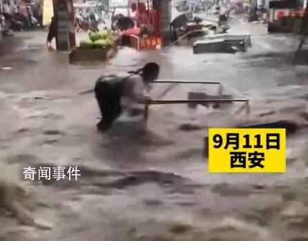 西安突降暴雨 2名商贩急流中被冲倒