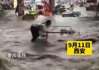 西安突降暴雨 2名商贩急流中被冲倒