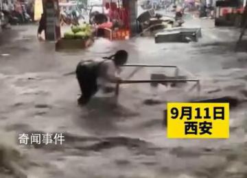 西安突降暴雨 2名商贩急流中被冲倒