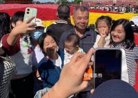 游客天安门广场花篮前拍下全家福